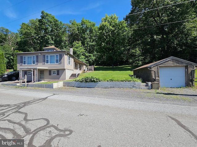 view of front of home featuring a front yard, a garage, and an outdoor structure