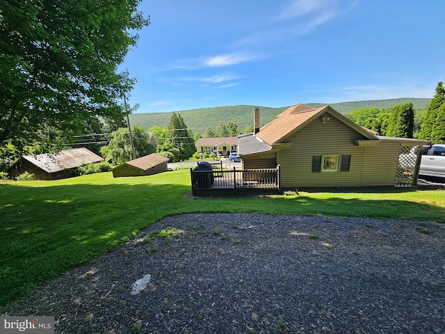 exterior space with a lawn and a deck with mountain view