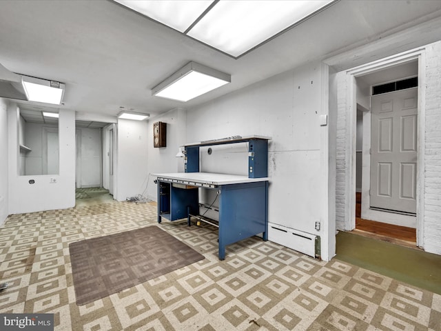 basement with a baseboard heating unit and brick wall