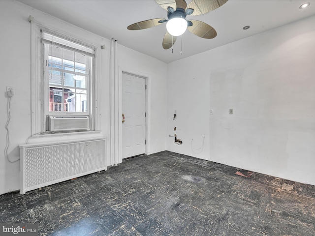 empty room featuring ceiling fan, radiator heating unit, and cooling unit