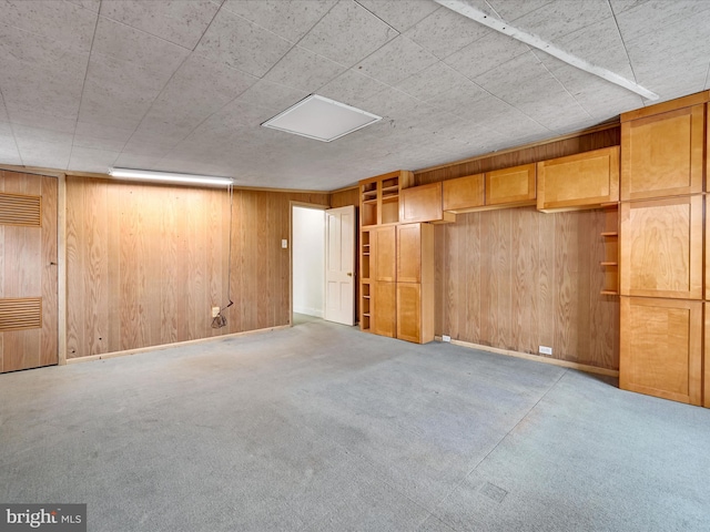 basement featuring wood walls and light carpet