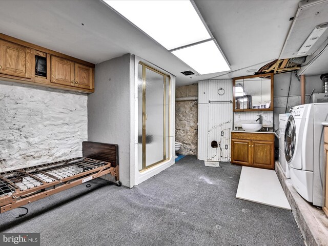 laundry area featuring washer and clothes dryer, carpet, cabinets, and sink