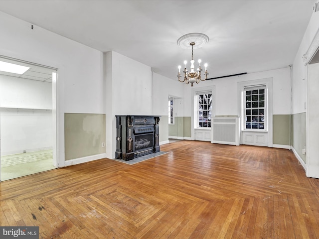 unfurnished living room featuring parquet flooring and a notable chandelier