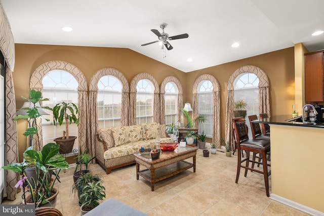 living room featuring ceiling fan, light tile patterned flooring, and lofted ceiling