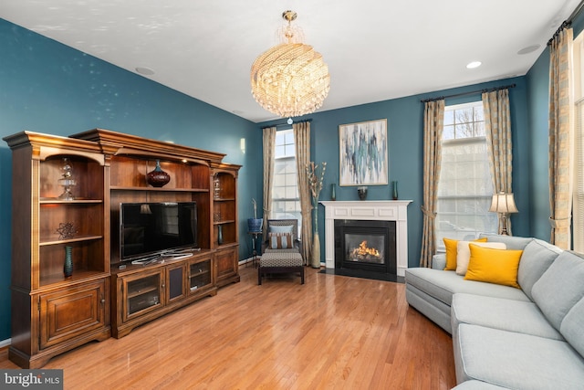 living room featuring a chandelier and light wood-type flooring