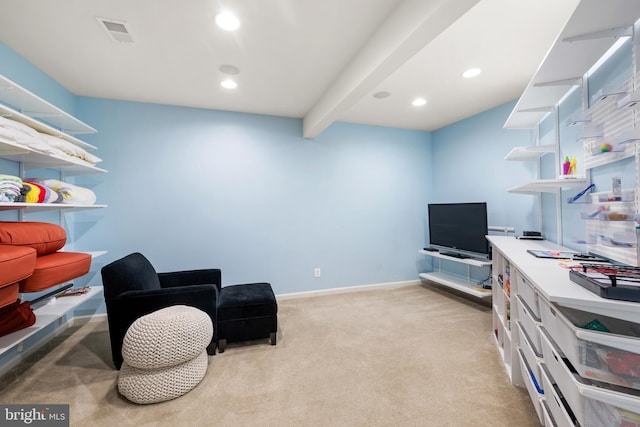 sitting room featuring light carpet and beamed ceiling