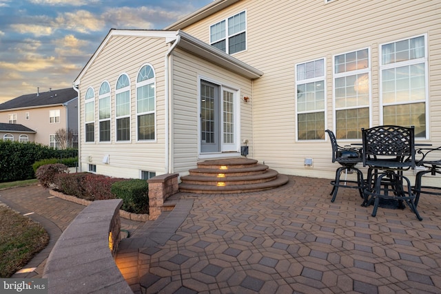 back house at dusk with a patio