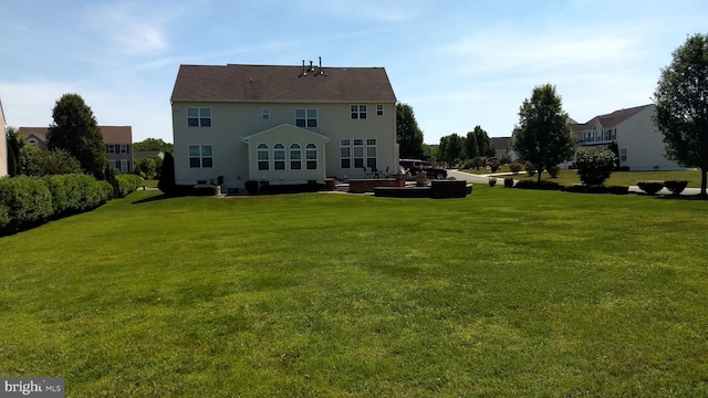 rear view of property featuring a lawn