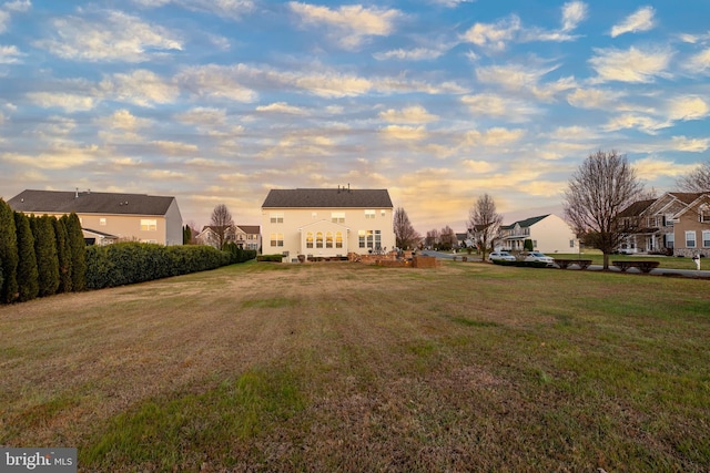 back house at dusk with a yard