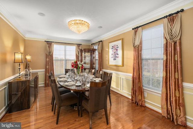 dining area featuring hardwood / wood-style floors, a chandelier, and ornamental molding