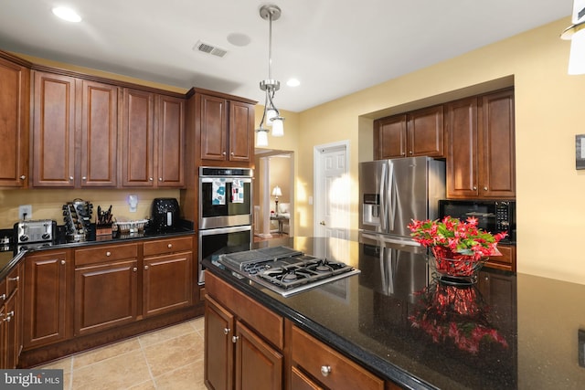 kitchen with decorative light fixtures, light tile patterned floors, appliances with stainless steel finishes, and dark stone counters