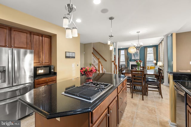 kitchen featuring decorative light fixtures, light tile patterned floors, appliances with stainless steel finishes, a notable chandelier, and a kitchen island