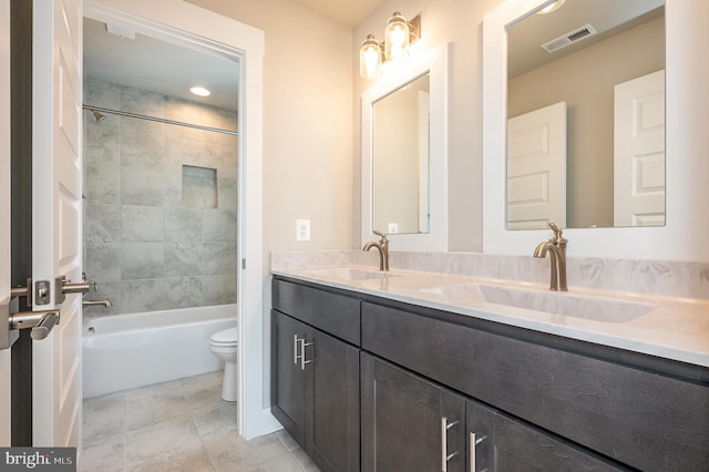 full bathroom with vanity, tiled shower / bath, and toilet