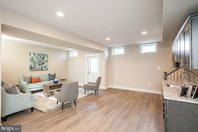 living room with sink and light wood-type flooring