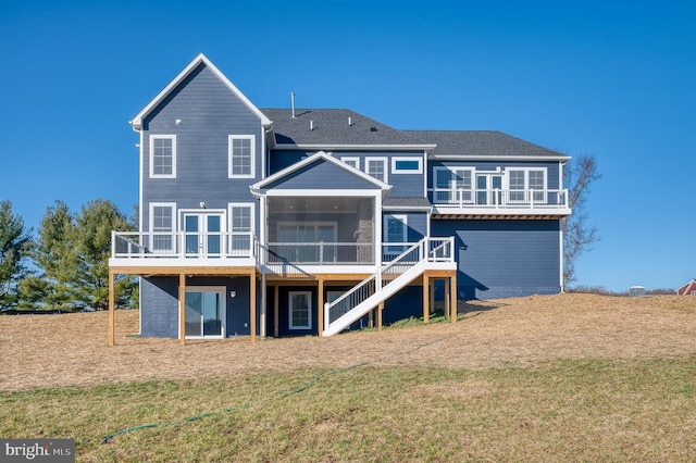 rear view of property featuring a sunroom and a lawn