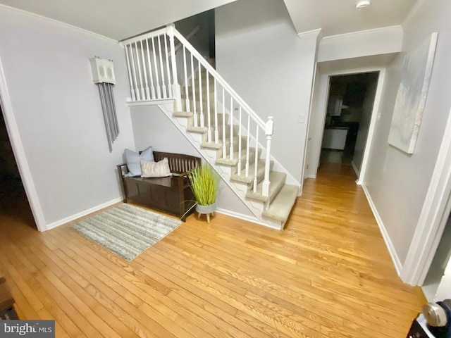 stairway with crown molding and hardwood / wood-style flooring