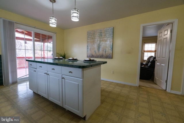 kitchen with a center island, white cabinets, pendant lighting, and plenty of natural light