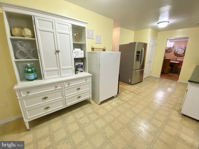 kitchen with white cabinets and stainless steel fridge