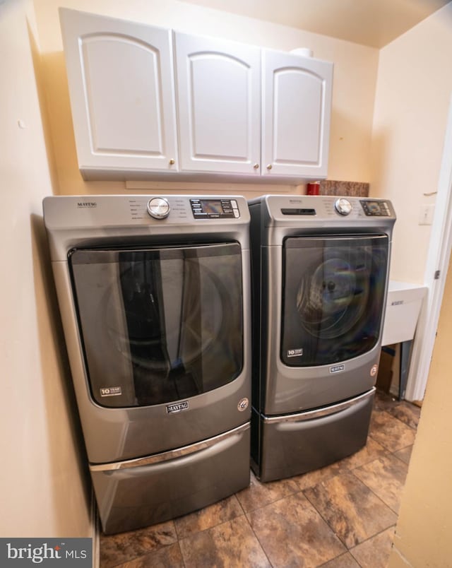 laundry area featuring cabinets and washing machine and dryer