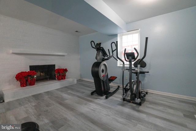 exercise area with wood-type flooring and a fireplace