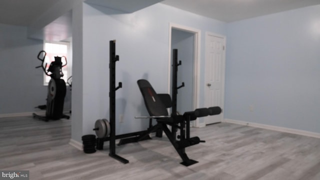 exercise room with light hardwood / wood-style floors