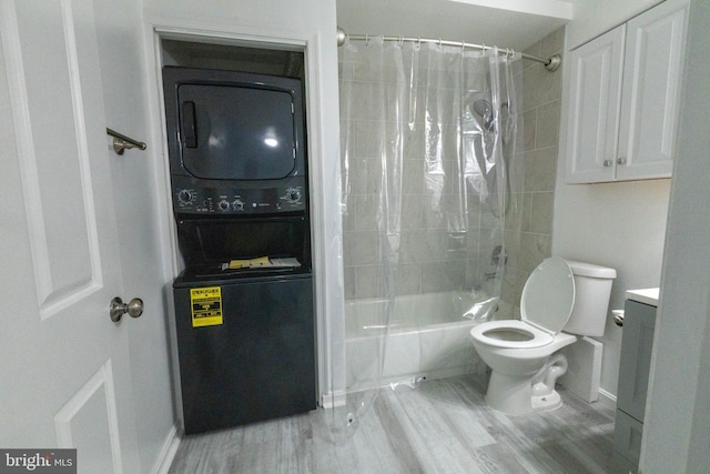 full bathroom with hardwood / wood-style floors, vanity, stacked washer and dryer, toilet, and shower / bath combo with shower curtain