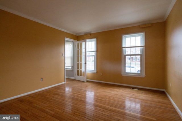 empty room with ornamental molding and light hardwood / wood-style flooring