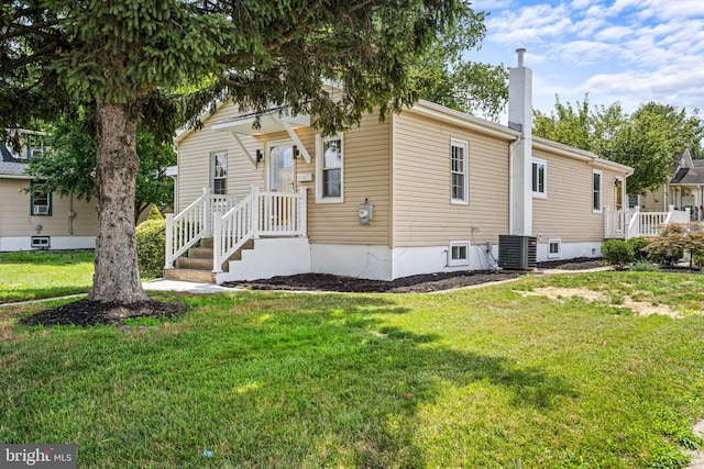 back of house with a yard and central air condition unit