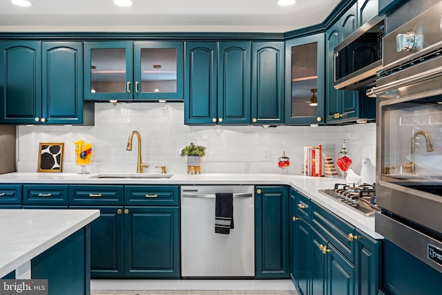 kitchen with sink, blue cabinets, and appliances with stainless steel finishes