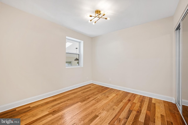 interior space with light hardwood / wood-style floors, a closet, and a notable chandelier