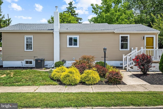 view of front of house featuring central air condition unit and a front yard