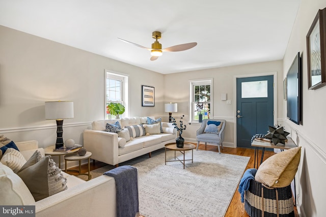 living room with ceiling fan and dark wood-type flooring