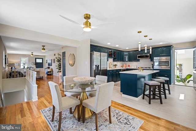 dining area featuring light wood-type flooring and ceiling fan