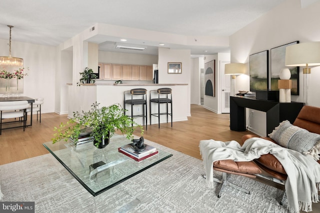 living room with a chandelier and light wood-type flooring