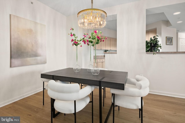 dining area featuring light hardwood / wood-style floors and a chandelier