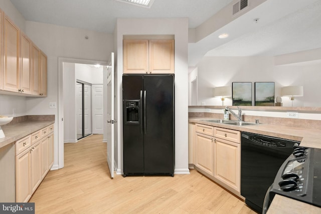 kitchen with light wood-type flooring, light brown cabinets, sink, and black appliances