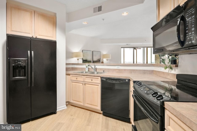 kitchen with light brown cabinetry, light hardwood / wood-style flooring, black appliances, and sink