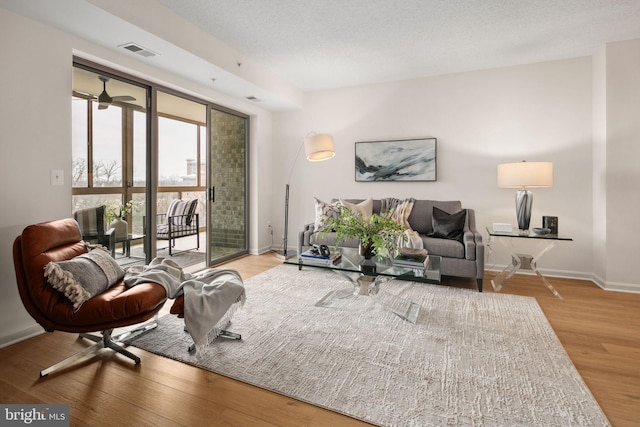 sitting room featuring a textured ceiling, hardwood / wood-style flooring, and ceiling fan