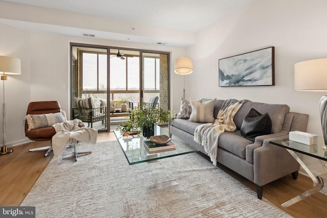 living room with light hardwood / wood-style floors and ceiling fan