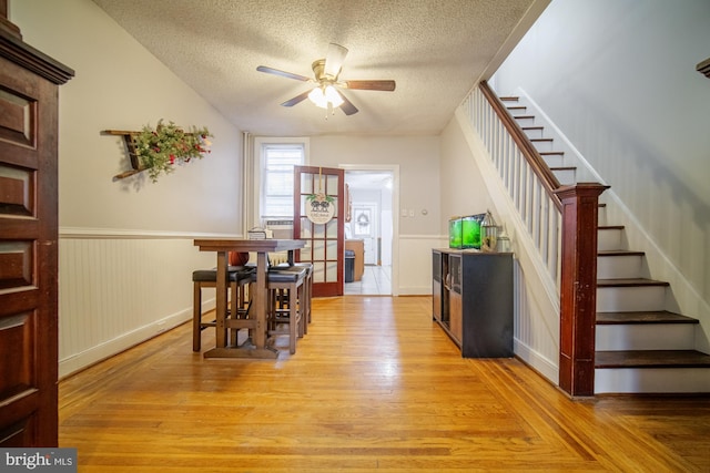 interior space with ceiling fan, a textured ceiling, and light wood-type flooring