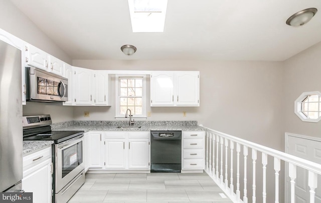 kitchen featuring plenty of natural light, white cabinetry, appliances with stainless steel finishes, and a skylight