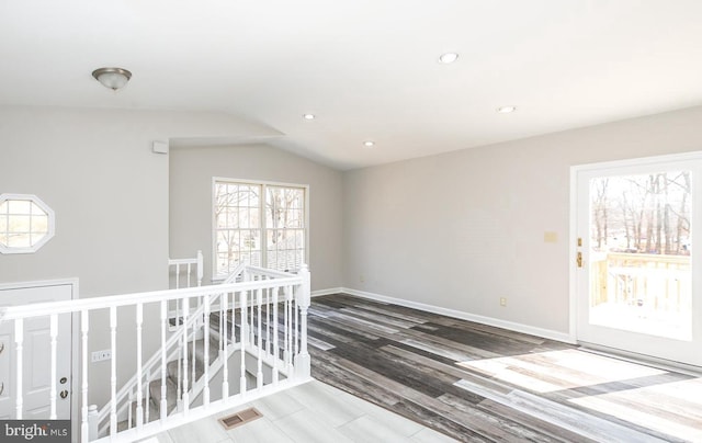 spare room with hardwood / wood-style floors and lofted ceiling