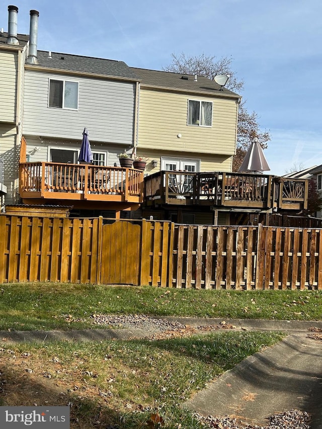 rear view of house featuring a wooden deck