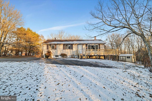 view of front of property with a storage shed and a wooden deck