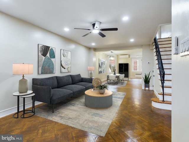 living room with baseboard heating, ceiling fan, and parquet flooring