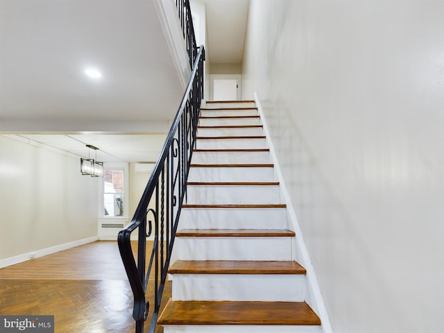 stairs with a chandelier and parquet flooring