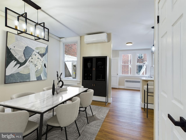 dining room featuring an AC wall unit, plenty of natural light, dark hardwood / wood-style floors, and an inviting chandelier