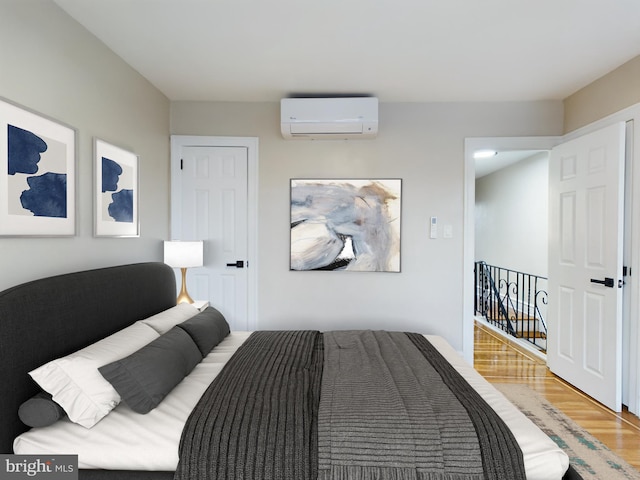 bedroom with wood-type flooring and an AC wall unit