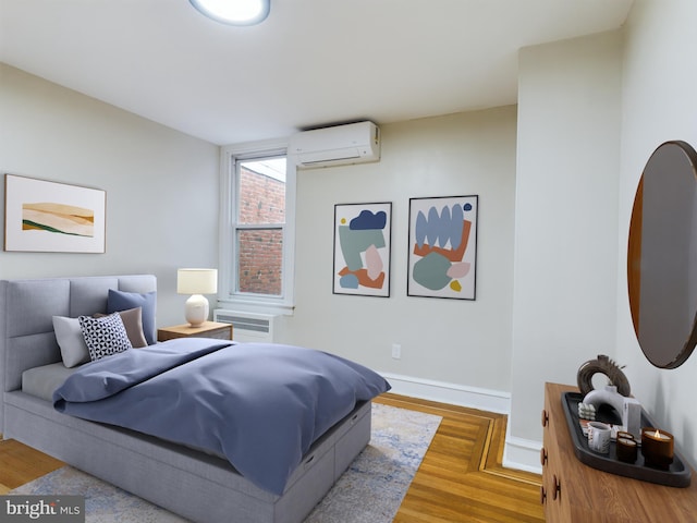 bedroom featuring hardwood / wood-style floors and an AC wall unit