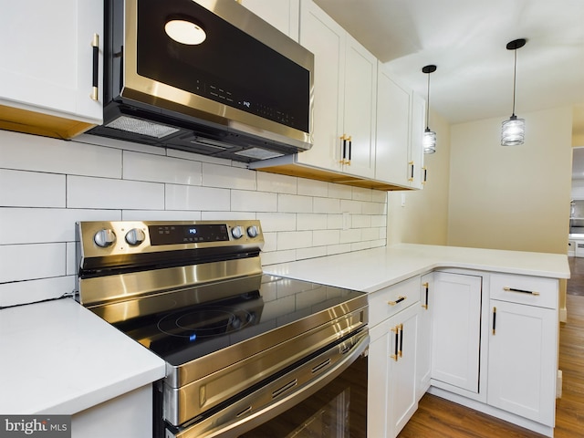 kitchen featuring white cabinetry, dark hardwood / wood-style flooring, decorative light fixtures, and appliances with stainless steel finishes